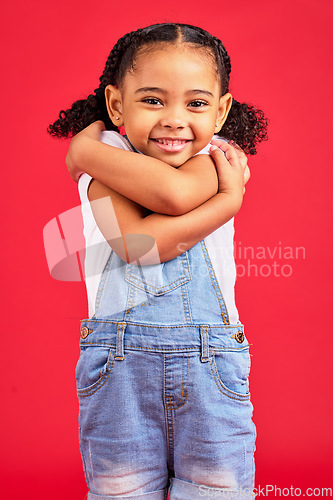 Image of Portrait, hug and girl in studio for self love, sweet and loving gesture against red background with mockup. Face, child and happy, smile and toddler embracing, care and confident while isolated