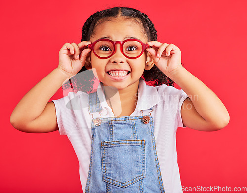 Image of Excited child, portrait or fashion glasses on red background in children trend, eyes care or wellness health. Smile, happy or little girl with optometry frames for vision support or medical insurance