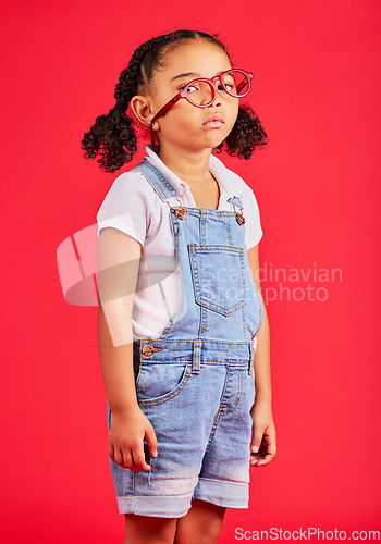 Image of Portrait, glasses and bored with a black girl on a red background in studio for vision or eyesight. Kids, sad or unhappy with a female child wearing a new frame prescription spectacles for correction