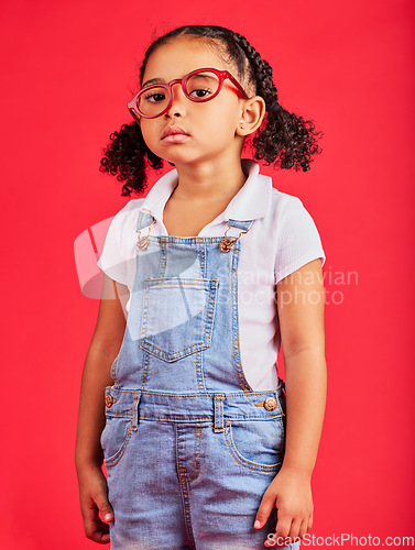 Image of Portrait, glasses and unhappy with a black girl on a red background in studio for vision or eyesight. Kids, sad or bored with a female child wearing a new frame prescription spectacles for correction
