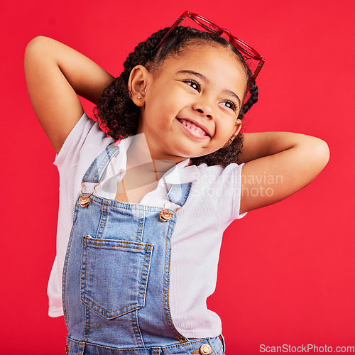 Image of Little girl, happy and thinking in fashion pose, trendy or cool style clothes on isolated red background for kids branding. Smile, youth and child stretching arms in playful, funny and goofy posing