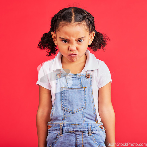 Image of Child, portrait or angry face on isolated red background in emoji tantrum, behavior or stubborn studio problem. Mad, annoyed or frustrated little girl and sulking, grumpy or anger facial expression