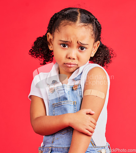 Image of Child portrait, sad and arm plaster in covid vaccine, injection and fall injury on isolated red background. Upset, unhappy and hurt girl and bandage in medical help, healthcare wellness and first aid