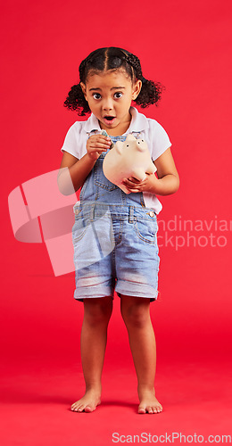 Image of Surprised child, portrait and piggy bank for money deposit, kids savings or future investment on isolated red background. Shocked, girl and wow kid with cash box for finance growth or budget planning