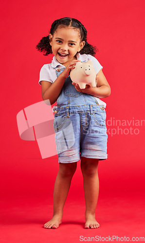 Image of Excited child, portrait and piggy bank in money planning, savings or future investment on isolated red background. Smile, happy and kid with cash box for finance growth, budget learning in studio