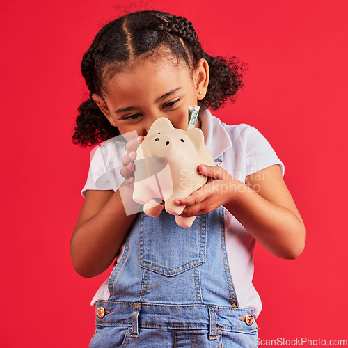 Image of Little girl, excited and piggy bank savings in money planning, finance management or future investment on isolated red background. Smile, happy child and cash box in finance growth or budget learning