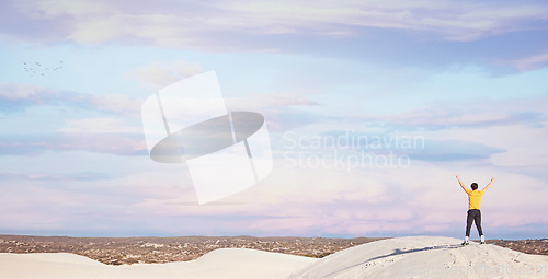 Image of Freedom, power and back of a man in the desert for adventure, travel success and holiday in Dubai. Free, peace and carefree traveller at the dunes on a vacation with victory, win and sunset view