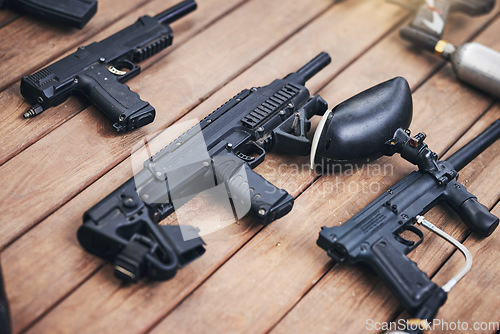 Image of Paintball, gun and equipment on a wooden table or surface from above for sports, recreation or fun. Team sport, safety and paint ball with weapons ready for a competitive game or match outdoor