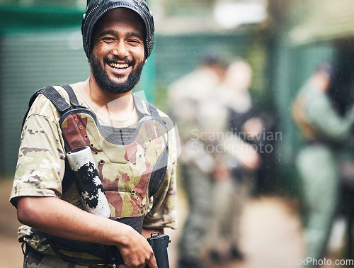 Image of Happy, portrait or man with paintball gun in games arena, team competition or sports challenge in military uniform. Smile, soldier or army person with shooting paint equipment in fun warfare training
