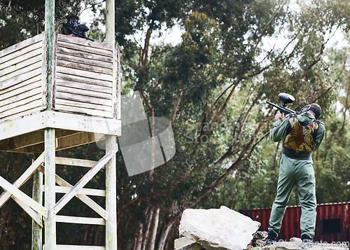 Image of Paintball, gun or man in a shooting game playing with fast action on a fun battlefield on holiday. Mission focused, military or player aiming with weapons gear for survival in an outdoor competition