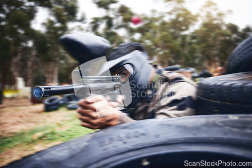 Image of Paintball, gun or man playing a shooting game with fast action on a fun battlefield on holiday. Military mission, fitness or player aiming with weapons gear for war survival in an outdoor competition