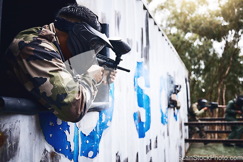 Image of Aim, gun or people in a paintball shooting game with fast action on a fun battlefield on holiday. Man on mission, playing or player with military weapons gear for survival in an outdoor competition