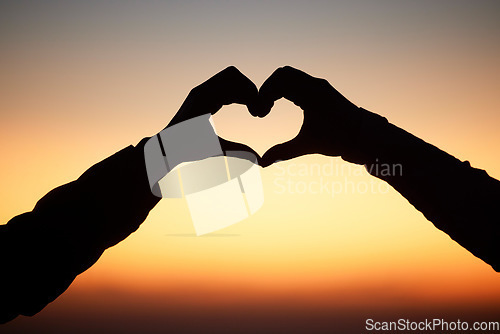 Image of Sunset, hands in heart and silhouette of couple at beach for romantic vacation, holiday and adventure. Emoji, travel and sky shadow of people relax, calm and together for trust, commitment and love