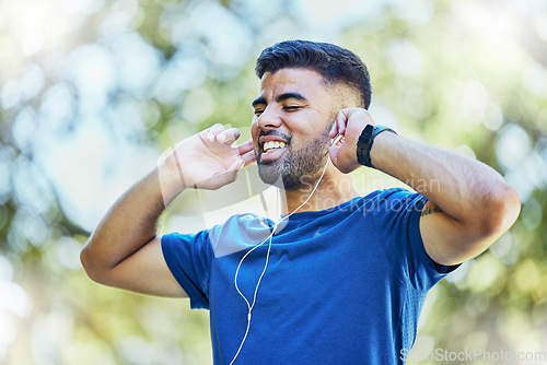 Image of Listening to music, fitness and exercise man with earphones outdoor at park for cardio training. Happy sports person or athlete in nature with podcast for a run and workout for health and wellness