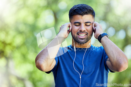 Image of Exercise, fitness and a man listening to music with earphones outdoor at park for cardio training. Happy sports person or athlete in nature with podcast for a run and workout for health and wellness