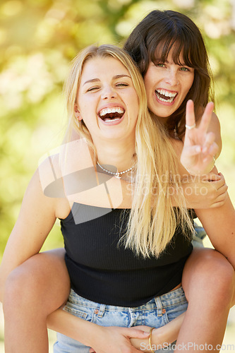 Image of Woman, friends and smile with peace sign for piggyback, friendship or summer holiday break together in nature. Happy women enjoying back ride, laughing or smiling for fun travel, trip or outdoor walk