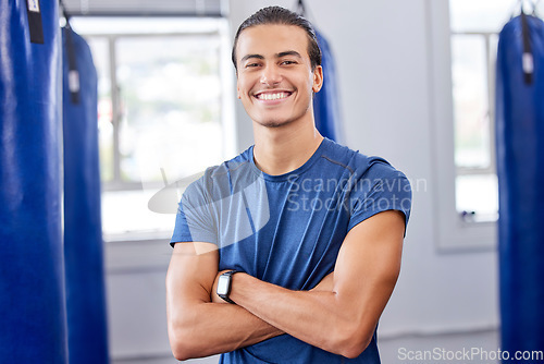 Image of Personal trainer man, gym portrait and arms crossed with focus, wellness and health in workplace. Happy coach, smartwatch and strong mindset for exercise, mma and boxing training in workout studio