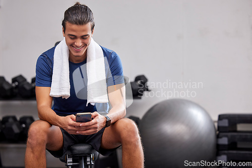 Image of Fitness, phone or man on social media to relax at gym in training, workout or exercise resting on a break. Tired, happy or healthy sports athlete typing text on a bench and exercising for body goals