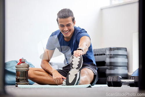 Image of Fitness, gym or man stretching legs starting training, workout or exercise warm up to relax muscles. Wellness, flexible or healthy sports athlete with a happy smile exercising in a studio in Brazil