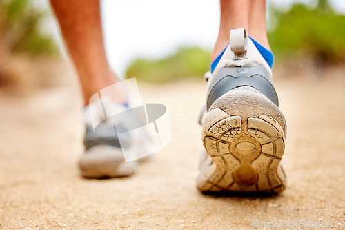 Image of Fitness, shoes and sports person walking, running and man training on path. Back closeup of runner, feet and sneakers on ground for exercise, park workout and outdoor trekking, hiking and wellness