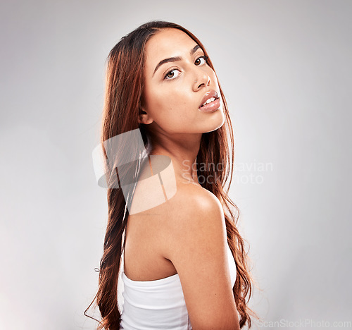 Image of Portrait, serious and woman in studio for hair, beauty and salon treatment on grey background. Face, haircare and model relax with luxury, hair care and shine, keratin and smooth results isolated