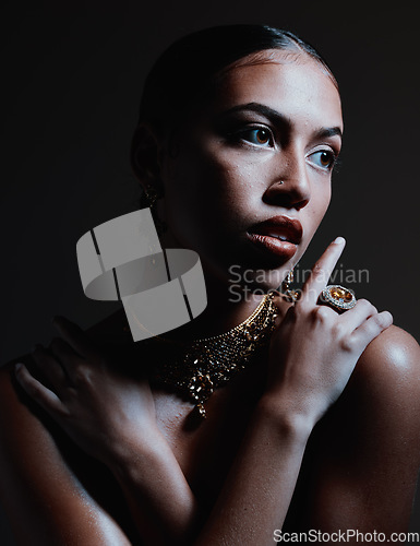 Image of Skincare, dark and woman with jewelry, cosmetics and treatment with girl on studio background. Makeup, girl and female with necklace, ring or grooming routine for natural beauty, wellness or backdrop