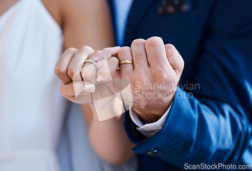 Image of Hands, pinky promise and wedding ring of bride with groom for outdoor celebration of partnership, care and love. Marriage commitment and trust of interracial couple at event with togetherness zoom