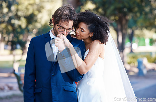 Image of Wedding, couple and kiss while holding hands outdoor at marriage celebration event together with commitment. Interracial man and woman with trust, partnership and respect or care in nature park