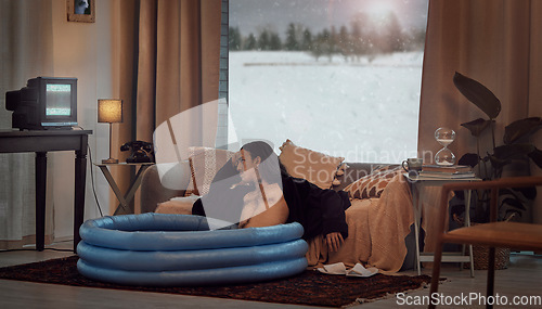 Image of Bored, man and in home sitting in pool in the lounge in a retro home watching vintage TV with no signal. Winter, snow and hipster relaxing in the living room in a house during vacation or a holiday