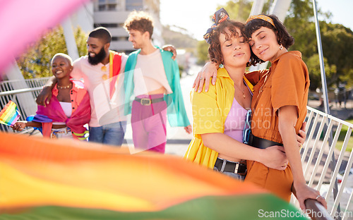 Image of Lgbt, city and couple of lesbian friends hug with rainbow flag for support, queer celebration and parade for love. Diversity, lgbtq community and group of people enjoy freedom and pride identity