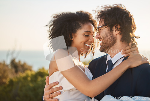 Image of Marriage, interracial couple and love hug in nature of people happy about trust and commitment. Outdoor carrying, sea and mock up at wedding with smile from bride and man in suit at partnership event