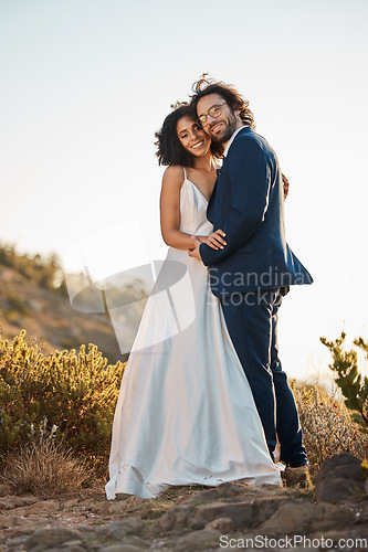 Image of Wedding bride and groom portrait at sunset with embrace together for love, care and connection in nature. Partner, soulmate and bond of interracial people at outdoor marriage celebration on hill.