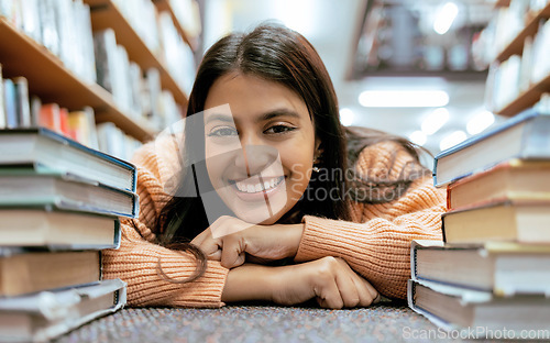 Image of Portrait, Indian woman on floor and books to relax, smile and hobby for learning, growth and education. Student on ground, female or academic in library, knowledge and rest after studying and college