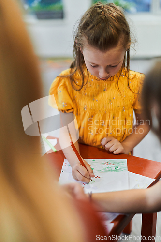 Image of Creative kids sitting in a preschool institution, draw and have fun while they get an education
