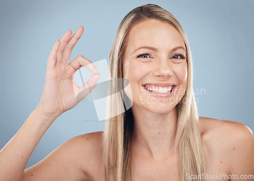 Image of Portrait, hand and perfect with a model woman in studio on a gray background for natural beauty. Face, skincare and gesture with an attractive young female posing to promote wellness or perfection