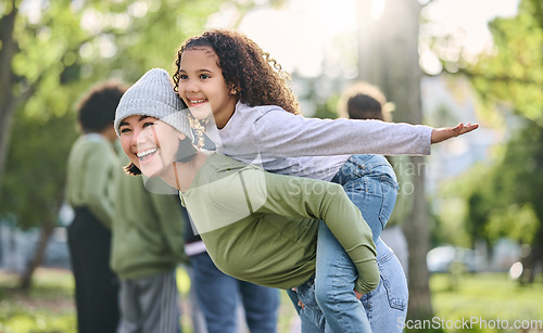 Image of Mother, piggy back and interracial family fun of a girl and mom together in nature. Park, happy summer and mama with love and care for child playing outdoor in a garden with blurred background