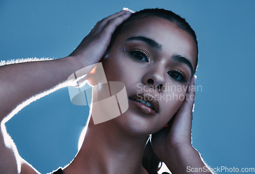 Image of Face portrait, beauty skincare and woman in studio isolated on a blue background. Makeup light, cosmetics and aesthetics of female model satisfied after facial treatment for healthy and glowing skin.