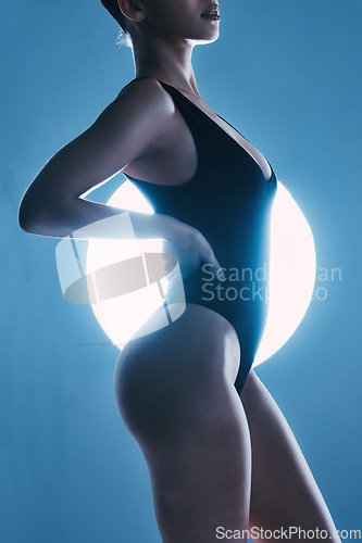 Image of Sexy, erotic and body of a woman with a spotlight isolated on a dark background in a studio. Fashion, curves and butt of a model posing for sensuality, seductive and stylish energy on a backdrop