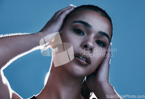 Image of Beauty skincare, face portrait and woman in studio isolated on a blue background. Makeup light, cosmetics and aesthetics of female model satisfied after facial treatment for healthy and glowing skin.