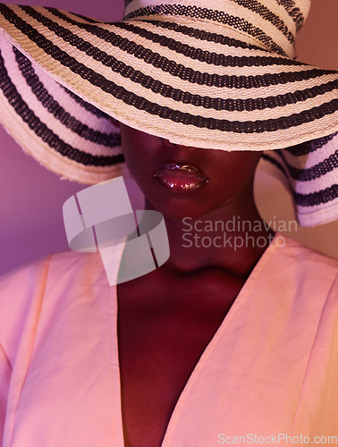 Image of Fashion, beauty and woman in neon light, UV and purple studio background wearing a sun hat. Style, makeup and African American female model with dark skin aesthetic creativity, color and design