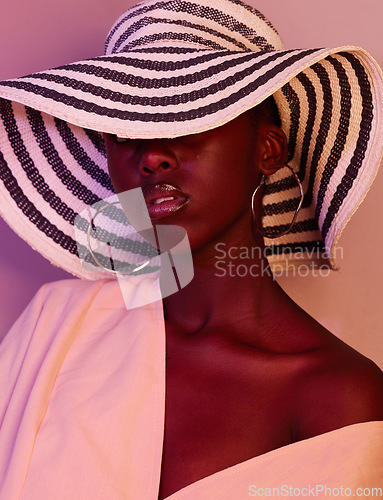 Image of Model, design and black woman fashion in neon, UV and purple light in studio background wearing a sun hat. Style, makeup and beauty by female with dark skin aesthetic creativity and color