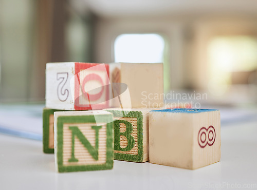 Image of Wooden blocks, table and letters for learning, education or childhood development at home. Colorful wood cube toys to learn numbers or alphabet for back to school, spelling or mathematics to read