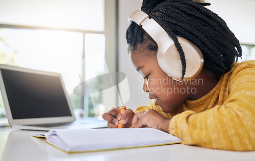 Image of Education, black girl and writing with headphones, homework and learning for growth, happy and notes. African American female child, kid or young person with focus, development or knowledge with book