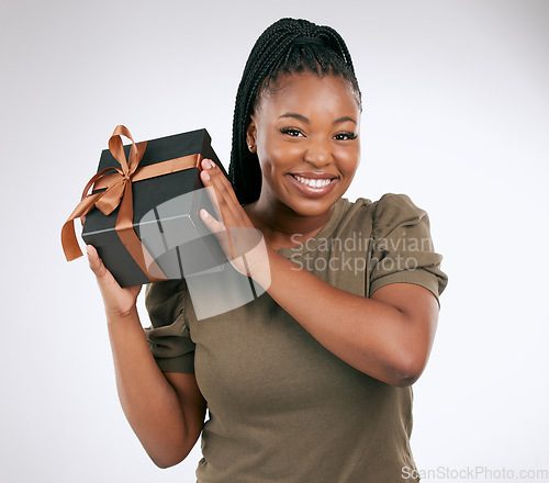 Image of Gift, box and portrait of woman on studio background, package or smile. Happy black female, present and surprise with ribbon, birthday celebration and excited giveaway, product promotion or happiness