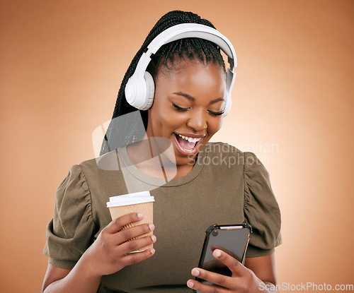 Image of Mobile, music and coffee with a black woman in studio on a beige background listening to the radio. Phone, social media or headphones and a young female streaming an audio playlist with a drink