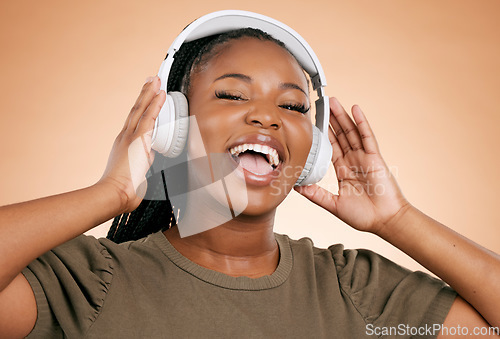 Image of Headphones, singing and portrait of woman isolated on studio background in mental health, energy and radio music. Singer, voice and gen z black people listening to sound, audio technology on mockup