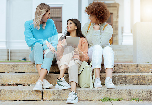 Image of Student, friends and tablet on stairs in conversation, social media or communication at campus. Happy women enjoying discussion, chat or talking with touchscreen together on staircase at university