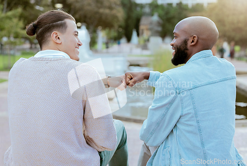 Image of Friends, students and men fist bump together on campus with smile, diversity and hope for future. Friendship, university and happy college people sitting outside, gen z man and friend with handshake.