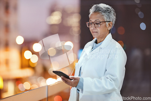 Image of Doctor, phone and senior woman on hospital rooftop for telehealth, research or online consultation in city. Bokeh, healthcare and female medical physician with smartphone for wellness app at night