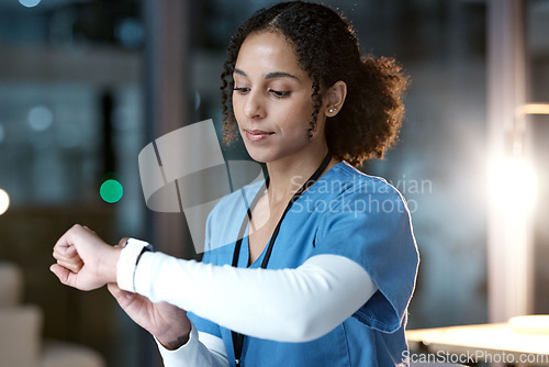 Image of Doctor, woman and wristwatch at night in clinic office for personal health, wellness or time. Medical expert reading, iot tech or smartwatch to monitor healthcare for blood pressure in dark hospital